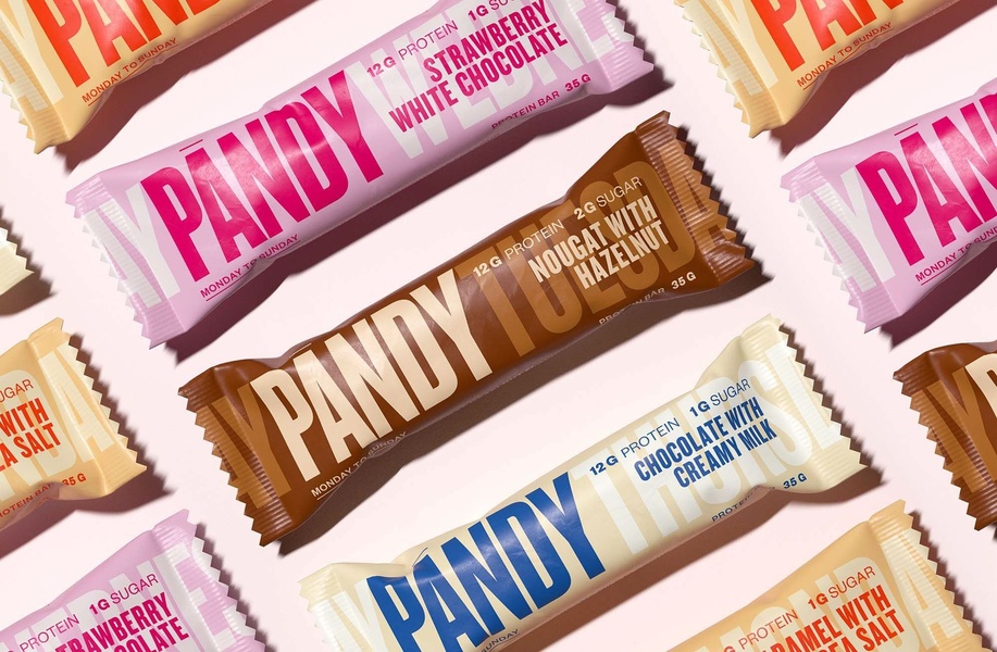 A high-quality, balanced flat lay showing various protein bar flavors organized in a grid layout to emphasize brand variety.